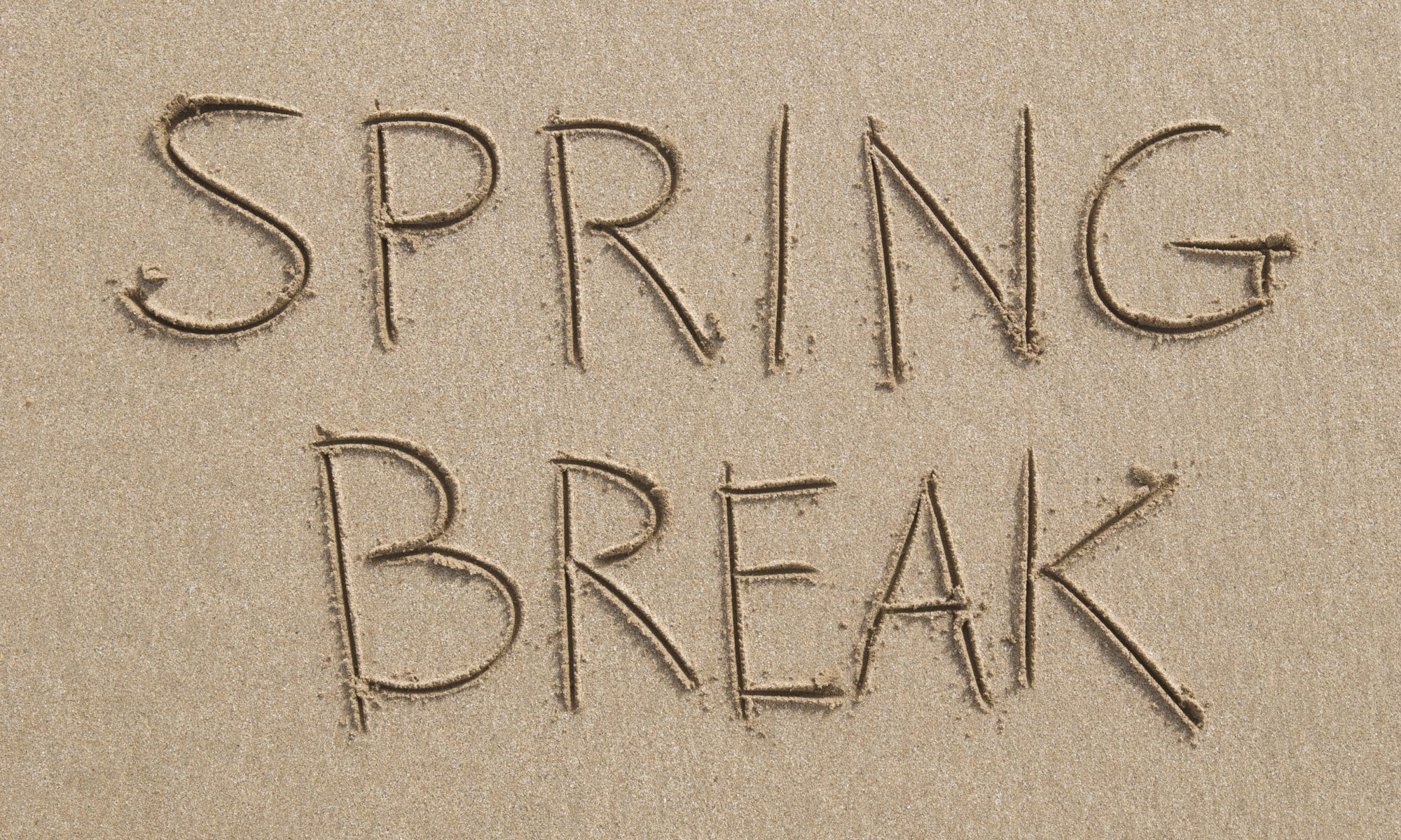 "Spring Break spelled out as clear as it gets in block letters in nice, soft, brown sand"